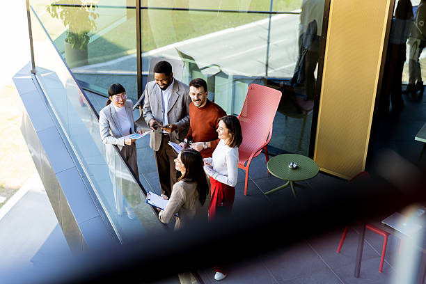 istock Group of professionals collaborating on project details in modern office space during sunny day 2213873834