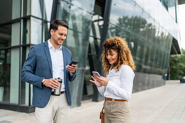 istock Businesspeople using smartphones outside office building 2213873881