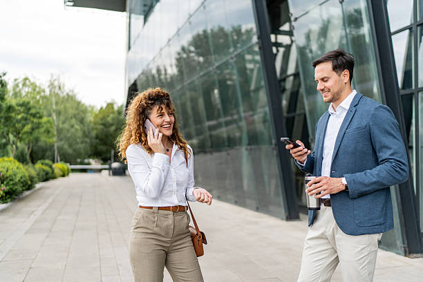istock Businesspeople using mobile phones outside office building 2213873925