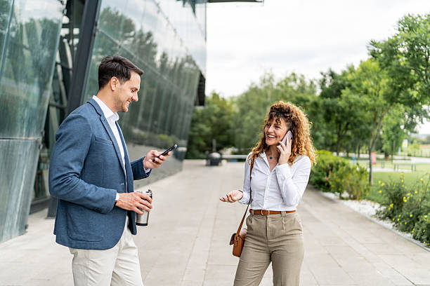 istock Businesspeople using mobile phones outside office building 2213873926