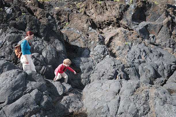 istock Mother and son exploring volcanic rocks on a sunny day 2213874380