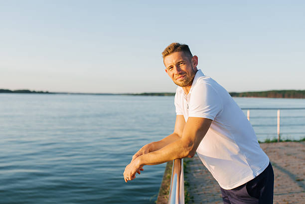 istock Relaxed Man by Lake During Sunset 2213876782