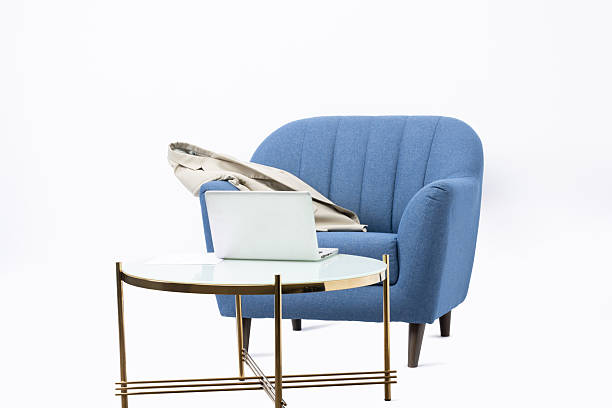 A cozy living room filled with warmth. The vibrant yellow chair stands out against the blue walls, creating an inviting atmosphere during the day.