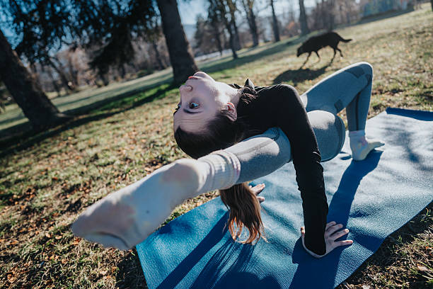istock Woman practicing yoga outdoors in a park on a sunny day 2213879758