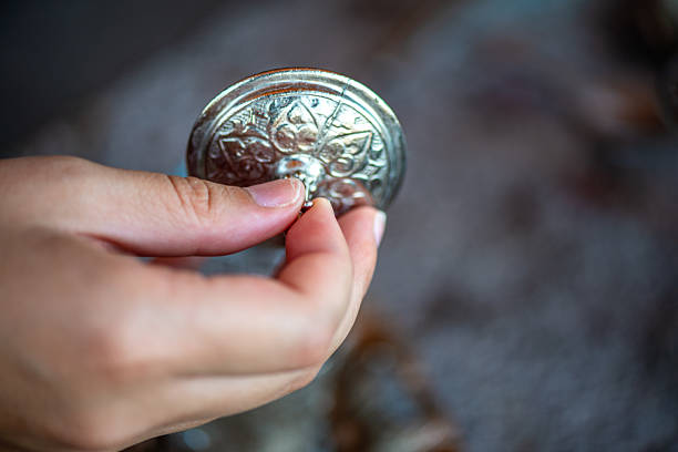 A detailed and atmospheric image of a traditional handcrafted Turkish coffee cup made of copper, placed on a weathered ancient stone surface.