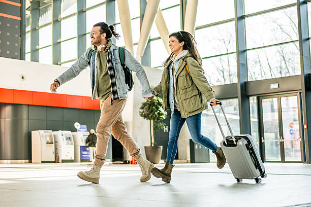 istock Young tourists running through airport terminal holding hands 2213882010
