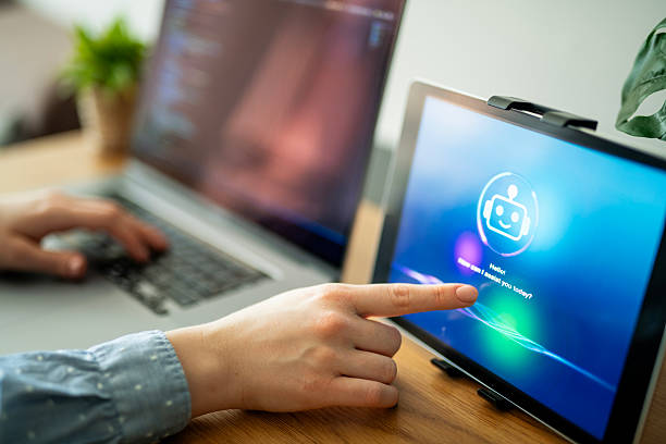 istock Woman programming and using AI chatbot app on digital tablet to assist her while working on laptop. 2213882512