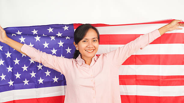 istock Female proudly waves US flag on white background 2213884398