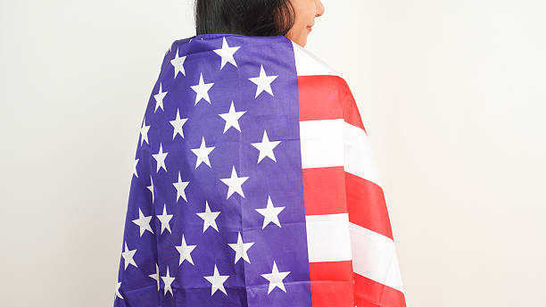 istock Patriotic female covered in US flag on neutral background 2213884723