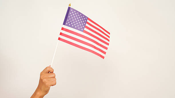 istock Isolated hand holding US flag, white background 2213884986
