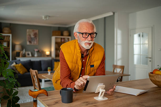istock Senior man using digital tablet at home, enjoying modern technology 2213888363