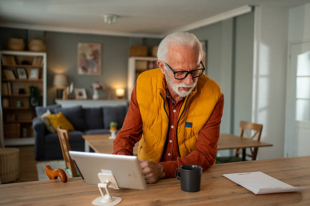 istock Senior man using digital tablet at home for managing bills and finances 2213888410