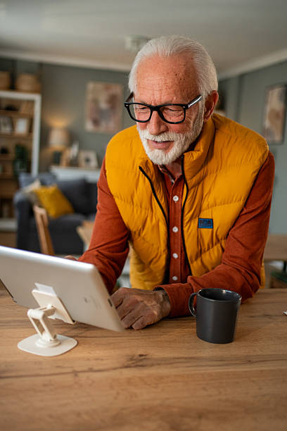 istock Senior man using digital tablet at home with coffee 2213888422