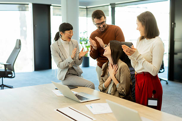 Team celebrates success together in a bright modern office environment