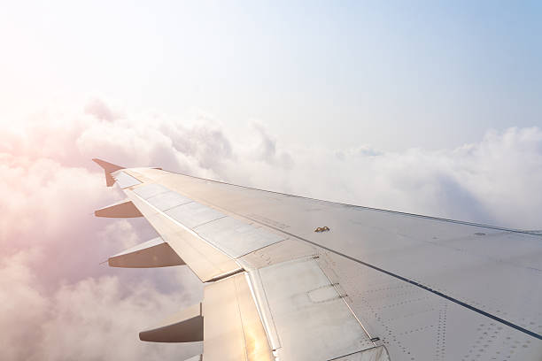 istock Flying high above the clouds with sunlight casting a warm glow on airplane wing during an early morning journey 2213893563