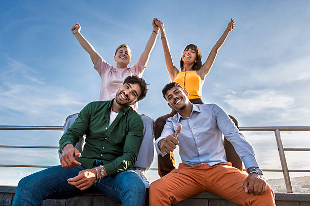 istock Happy multicultural friends celebrating success under blue sky at sunset 2213894551