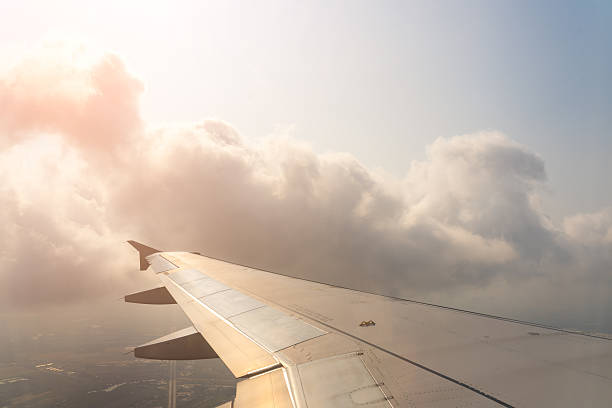 istock Clouds drift peacefully as an airplane wing glides through the sky during a tranquil sunset journey over distant landscapes 2213894817