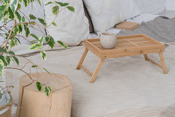 istock Cozy bed in beige interior and green plants 2213894889