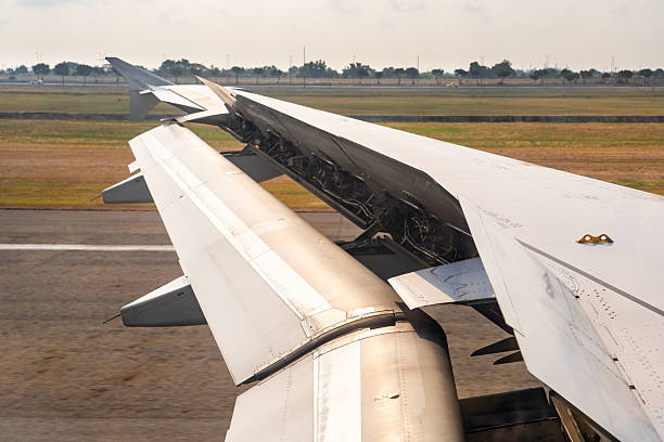 istock Airplane wing close-up reveals intricate details while preparing for takeoff at a bustling airport under a bright sky 2213895395