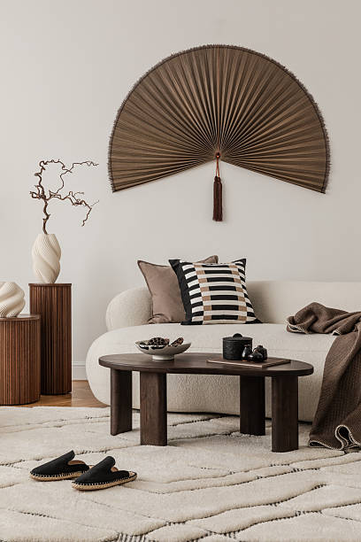 istock Contemporary interior with fan-shaped wall decor, soft sofa and sculptural vases in neutral tones. 2213897727