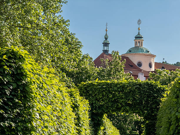 Prague, may 7 2025 ,scenic view of thesenate garden, a unesco world heritage site, with its meticulously trimmed hedges and the dome of st. Lawrence church in prague, czech republic