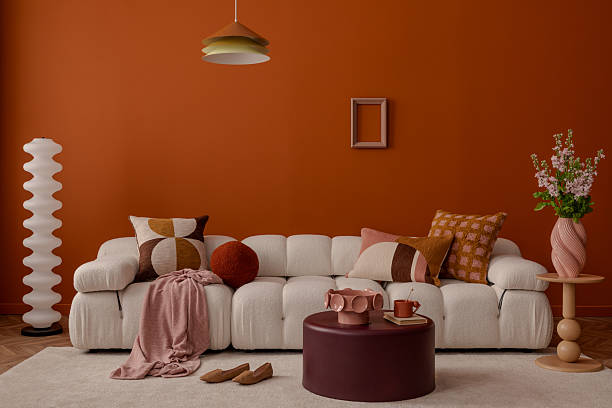 istock Stylish living room with soft textures, patterned pillows and bold pendant. Orange is a new black. 2213899509