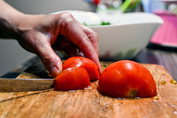 istock Woman chops tomatoes for salad 2213899913