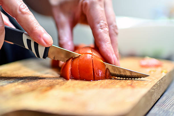 istock Woman chops tomatoes for salad 2213899914