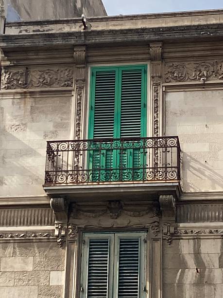 istock Bracketed wrought iron balcony with green wooden shutters 2213902155