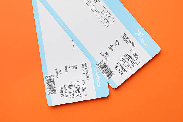 istock Travel agency. Flight tickets on orange background, top view 2213903875