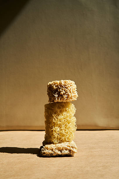 Creative food composition of ramen noodles over beige.