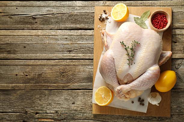 istock Uncooked turkey, lemon and spices on wooden table, top view. Space for text 2213904152