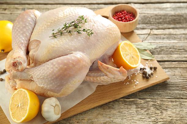 istock Uncooked turkey, lemon and spices on wooden table, closeup 2213904213