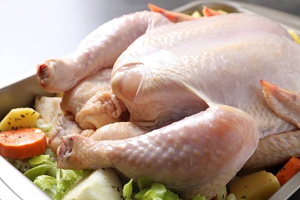istock Raw turkey and vegetables in baking dish on grey table, closeup 2213904220
