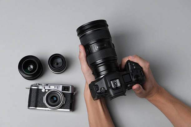 istock Photographer with professional camera on grey background, top view 2213904263