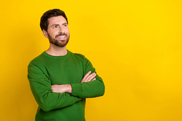 istock Portrait of attractive guy experienced worker hold folded arms looking interested empty space ad isolated yellow color background 2213904750