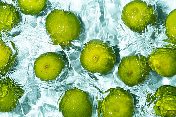 istock Green Limes Floating on Calm Water Background 2213904974