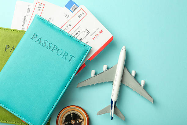 istock Passport with tickets, compass and plane model on light blue background, top view 2213905391