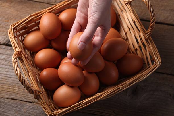 istock Woman with raw eggs at wooden table, top view 2213906113