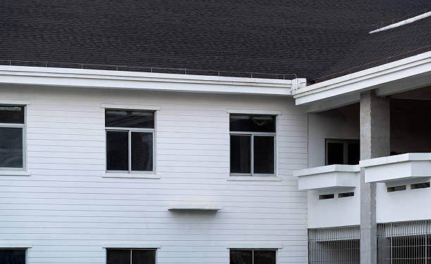 Tan house siding framed by a crystal blue sky