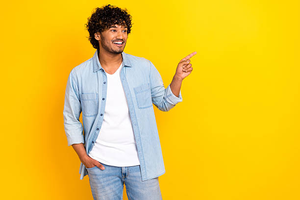 istock Photo of charming dreamy guy dressed denim jacket looking showing finger empty space isolated yellow color background 2213908870