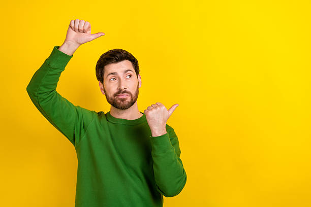 istock Photo of intelligent business man agent green pullover indicate fingers empty space look creative promo isolated on yellow color background 2213908896
