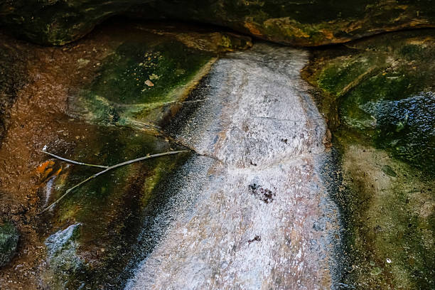 Textured surface of a hydrogen sulfide spring in a natural setting in the Carpathians, Ukraine. Mineral-rich rock formations where water has deposited sulfur compounds.