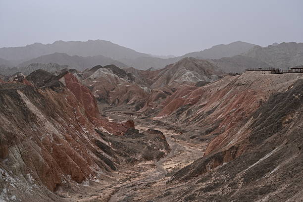 Zhangye's rainbow-colored Danxia landforms paint a surreal geological masterpiece, with layered hues of red, gold and blue under dramatic desert skies.