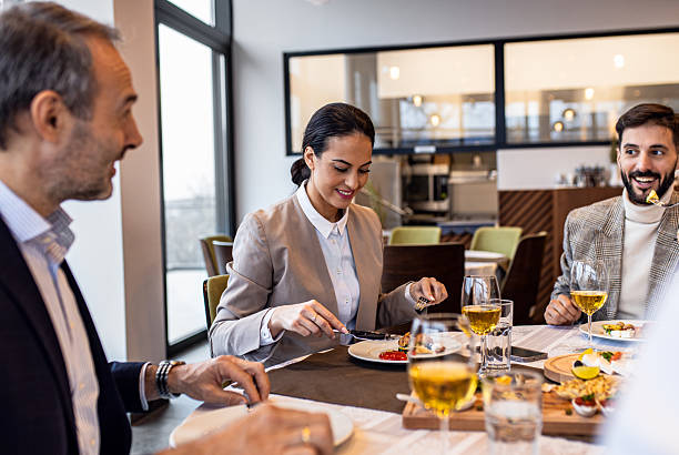 istock Smiling coworkers in restaurant talking during business lunch. 2213909348