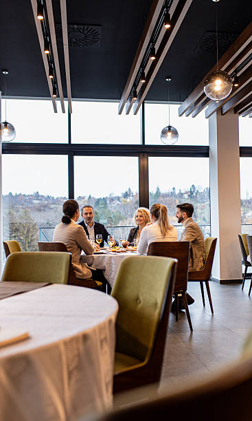 istock Smiling coworkers in restaurant talking during business lunch. 2213909399