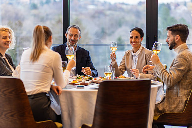 istock Smiling coworkers in restaurant talking during business lunch. 2213909505