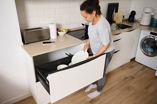 istock Woman Organizing Dishware in a Modern Home Kitchen Setting 2213910220