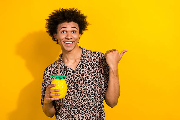 istock Photo of optimistic nice guy dressed leopard shirt hold cocktail directing at party empty space isolated on yellow color background 2213912478