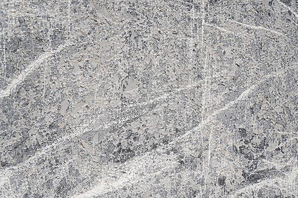High-resolution close-up of gray stone texture with natural patterns, cracks, and layered minerals. Ideal for backgrounds, design surfaces, or geology themes